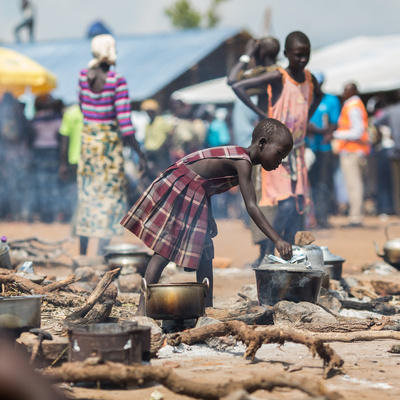 Uganda. A young South Sudanese refugee cooks food at a camp in northern Uganda