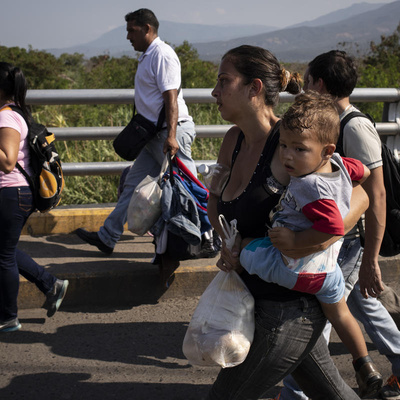 A Venezuelan mother holds her child as she crosses the Simon Bolivar Bridge to Colombia, in  January 2019.