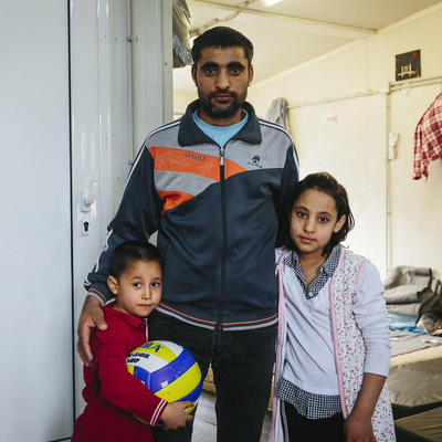 An Afghan asylum-seeker stands with two of his children at a reception centre in Fylakio, Greece, in February 2020.