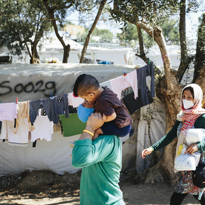  An Aghan refugee family walks through an informal camp outside the Moria Reception and Identification centre on the island of Lesbos, September 1, 2020.

