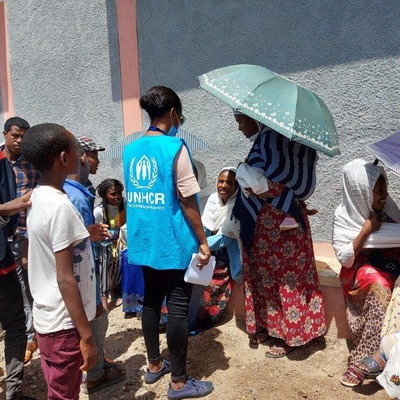 A UNHCR staff member speaks to internally displaced people in the street in Axum, in the Tigray region of Ethiopia. 