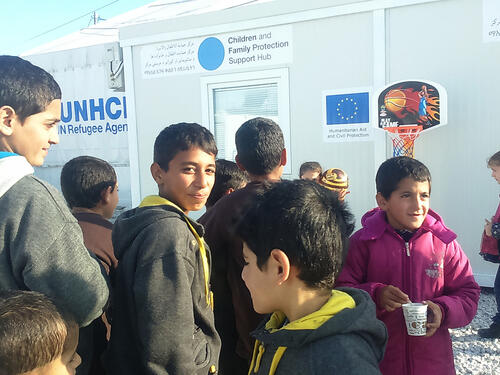 A group of children stand outside the Blue dot Children and Family Protection support centre.