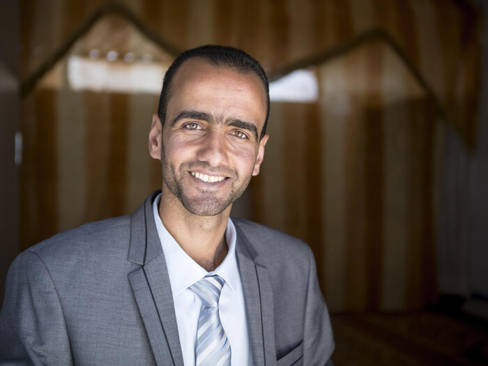 UNHCR, the UN Refugee Agency - Monther Alhoshan smiles happily into the camera, wearing a suit and a tie. One week ago he graduated in law from nearby Al-Albayt University,
