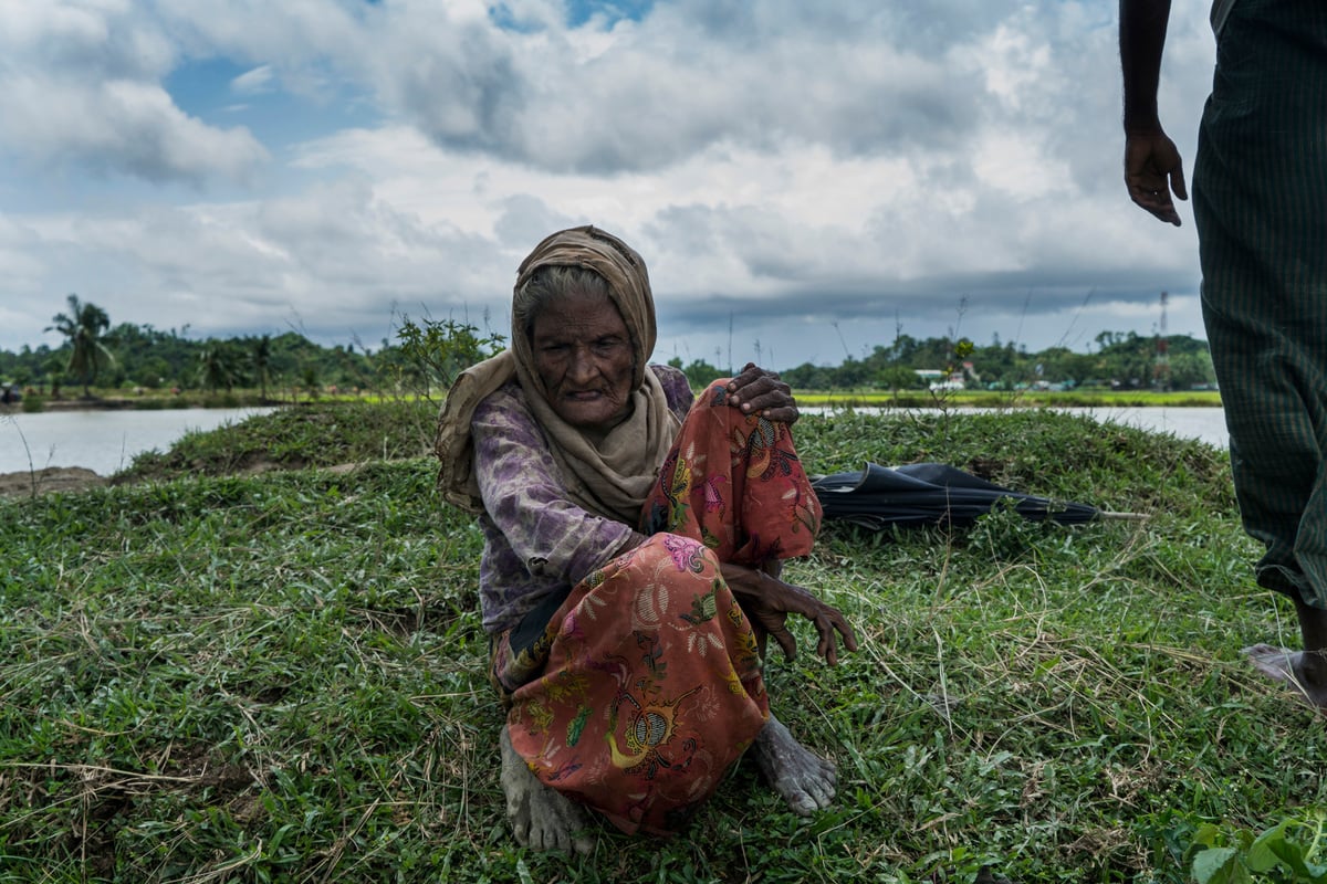 Bangladesh. An elderly Rohingya refugee is helped across the border
