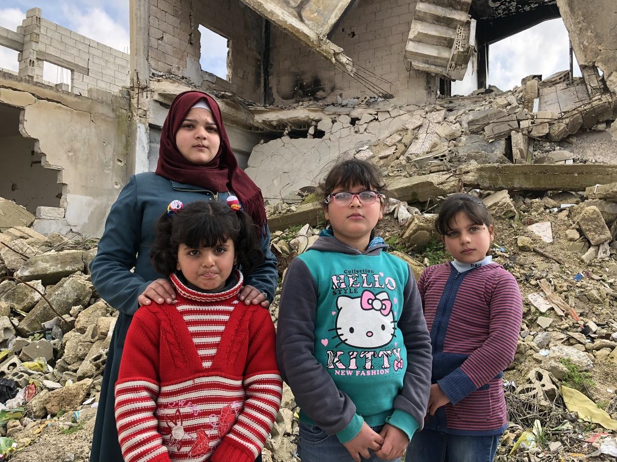 Zahida's four daughters pose by the ruins of their home in Souran, Syria. 