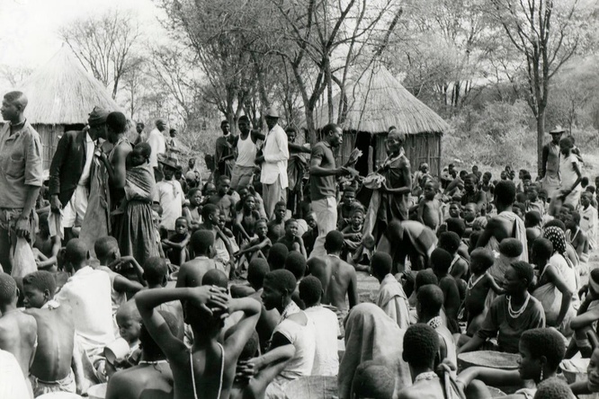 Black and white photo of a group of Angolan refugees waiting for food rations