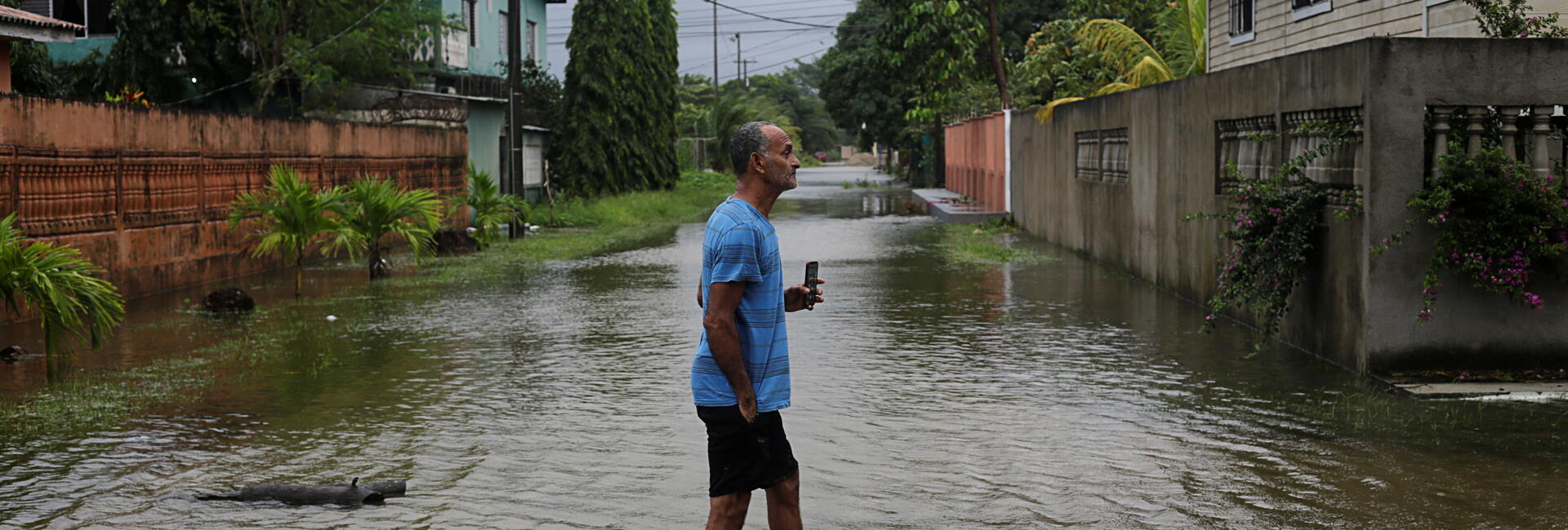 A man walks through a flooded street in Tela, Honduras as Hurricane Eta approaches (3 November, 2020).