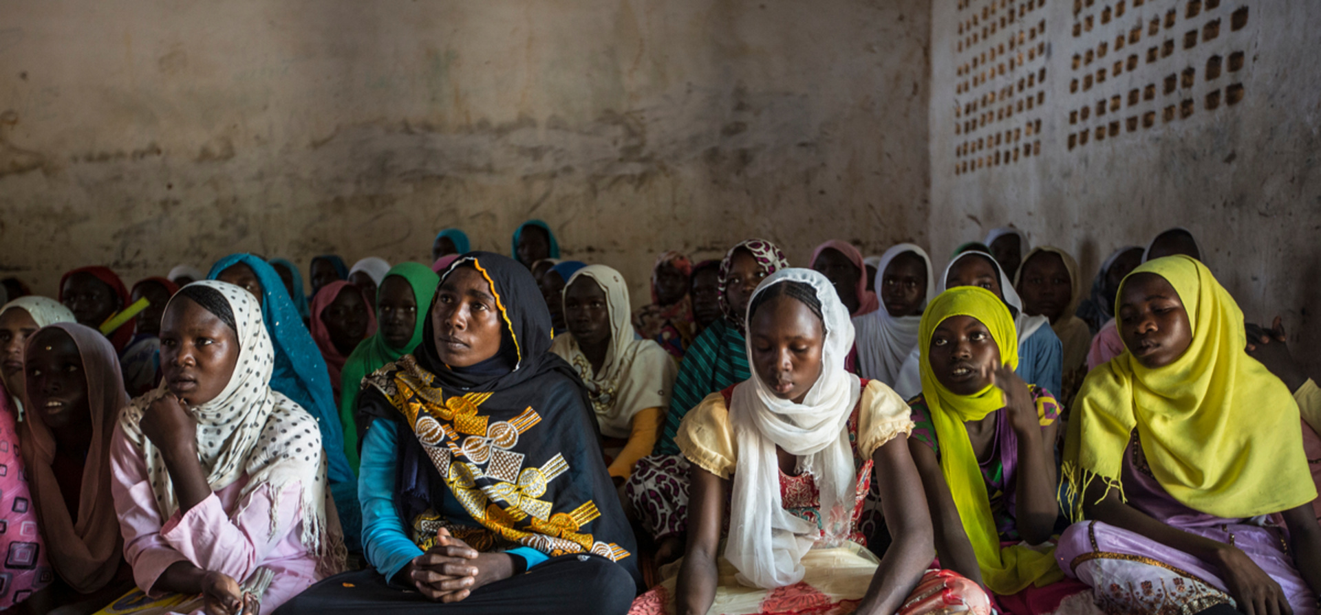 Chad. Refugee mother and her children study together