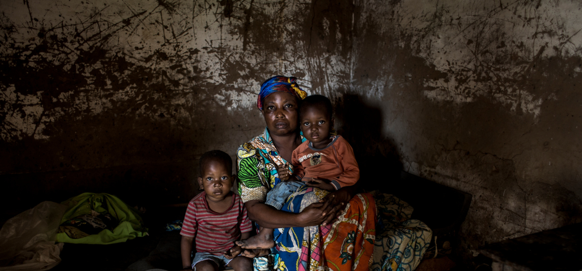 Democratic Republic of Congo. An internally displaced women sits with children in her house that was destroyed during fighting.