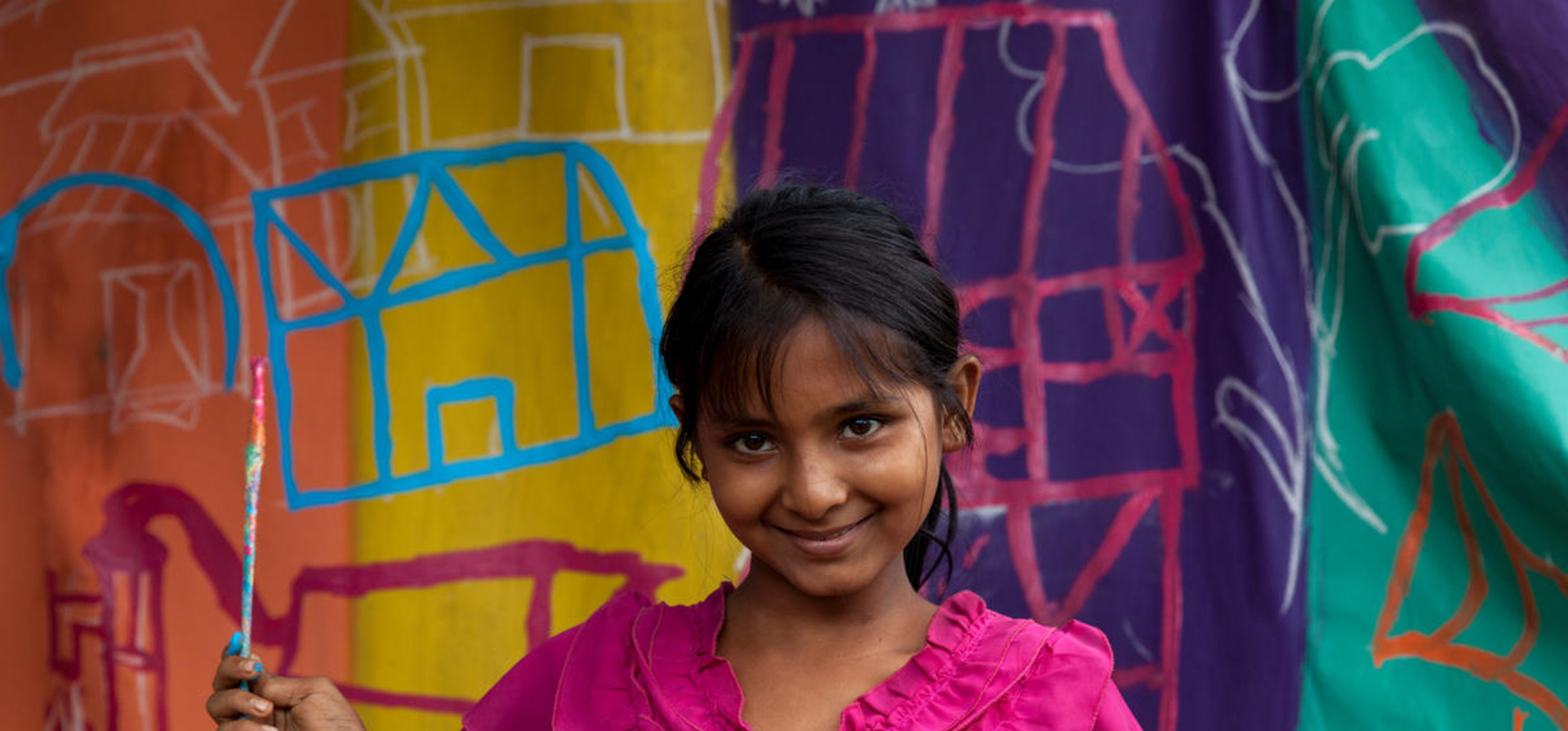 Bangladesh. A child painting a UNHCR tent