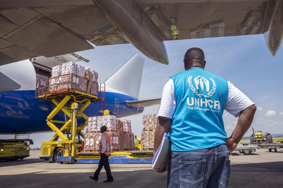 UNHCR, the UN Refugee Agency - A UNHCR staff and an airport worker unload the cargo of a Dubai Royal Wings Boeing 747 jet after it landed at Entebbe International Airport in Uganda with 100 tons of emergency aid supplies on board.