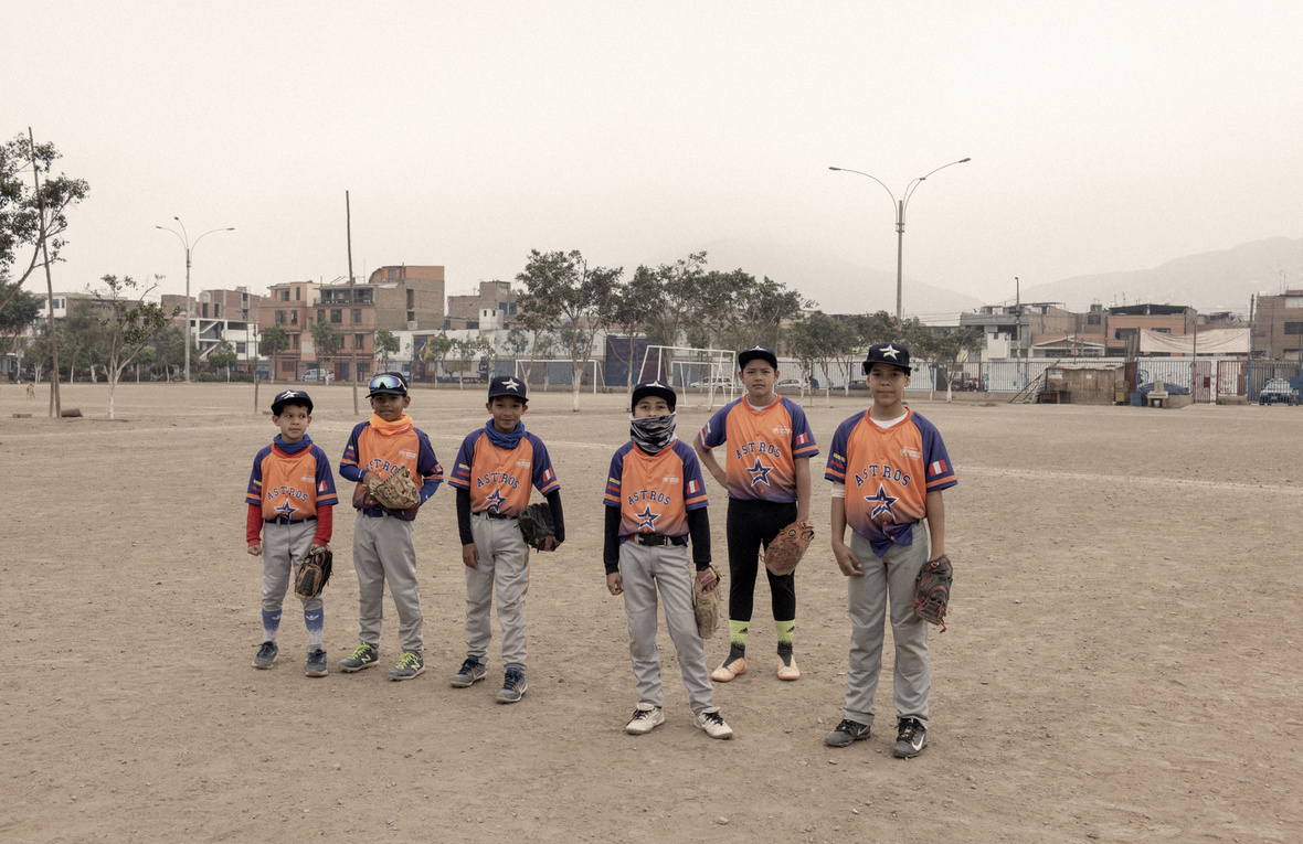 Six boys in baseball uniforms attend a traning session