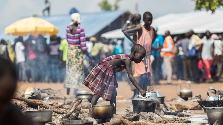 Uganda. A young South Sudanese refugee cooks food at a camp in northern Uganda