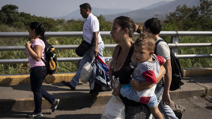 A Venezuelan mother holds her child as she crosses the Simon Bolivar Bridge to Colombia, in  January 2019.