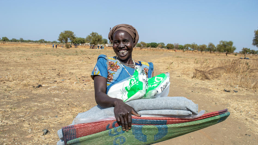 A woman from South Sudan's refugee-hosting community collects her UNHCR core relief items in Bunj, Maban county.