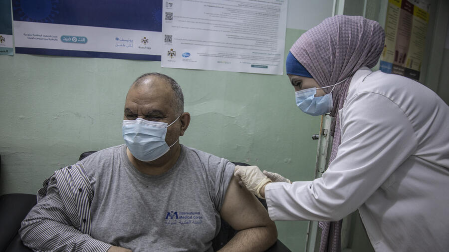 Iraqi refugee Ziad receives a dose of COVID-19 vaccine at the Irbid Vaccination Clinic in Jordan.