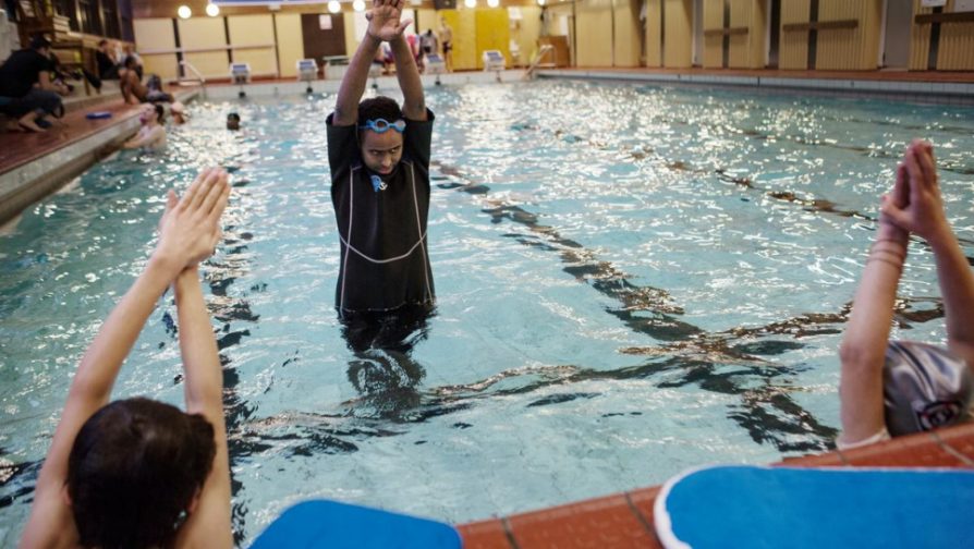 Abdullahi lærer de syriske flyktningene Shayma og Omar å svømme.