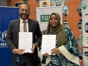 UNHCR Representative in Nigeria, Arjun Jain (left), and Habiba Sulaiman of TGI Group display the signed partnership agreement to expand livelihood opportunities for refugees, IDPs and host communities in Nigeria.