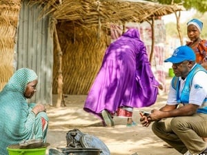 UNHCR staff member speaking with a woman during a field visit in Nigeria