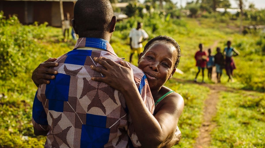 A former refugee from Côte d'Ivoire hugs his aunt.