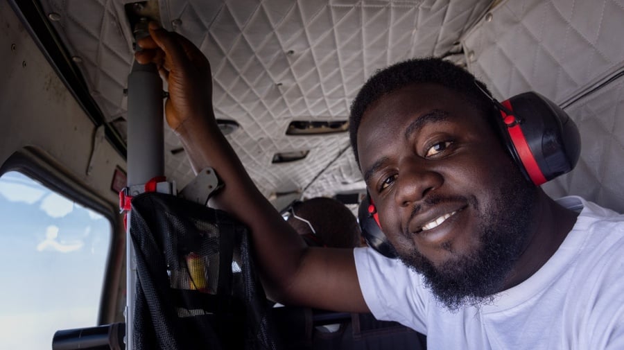 UNHCR Field Associate Iliya Ishira travels by helicopter to Banki, Borno State, to support displaced and returning communities. © UNHCR/Andrew Prior 