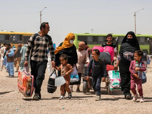 Een Afghaanse familie keert terug naar huis vanuit Iran na het oversteken van de grens bij Islam Qala in de Afghaanse provincie Herat in juli 2025.