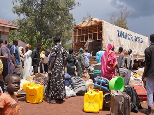 Soedanese mensen laden hun bagage uit van een vrachtwagen van UNHCR bij het Kiryandongo opvangcentrum in het noordwesten van Oeganda.