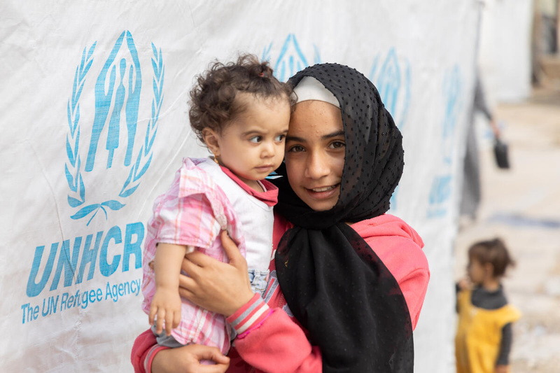 Lebanon. Gharam holding baby Reham, inside their makeshift tent in Bhanin village...