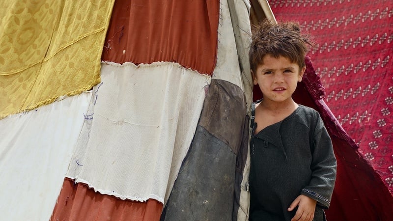 A child standing next to a tent
