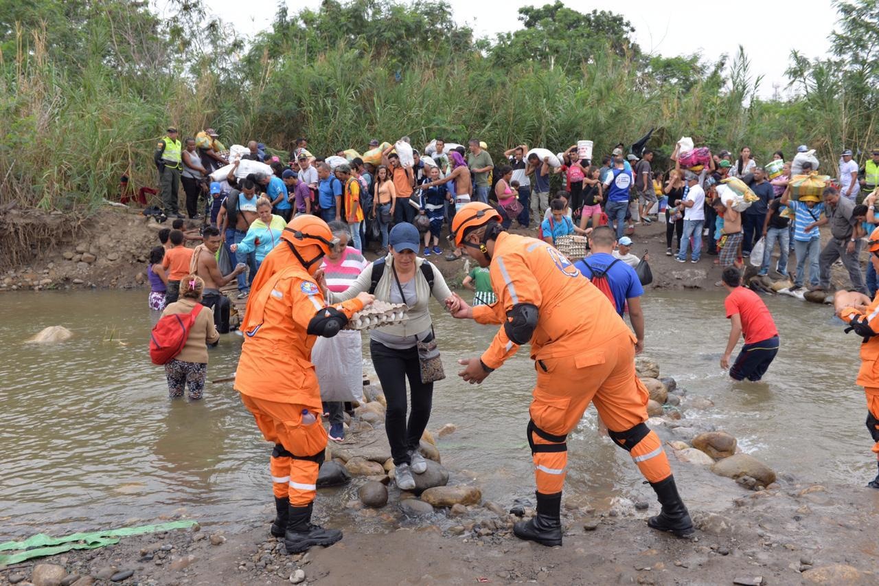 Met honderden tegelijkertijd waden mensen de rivier door tussen Colombia en Venezuela.
