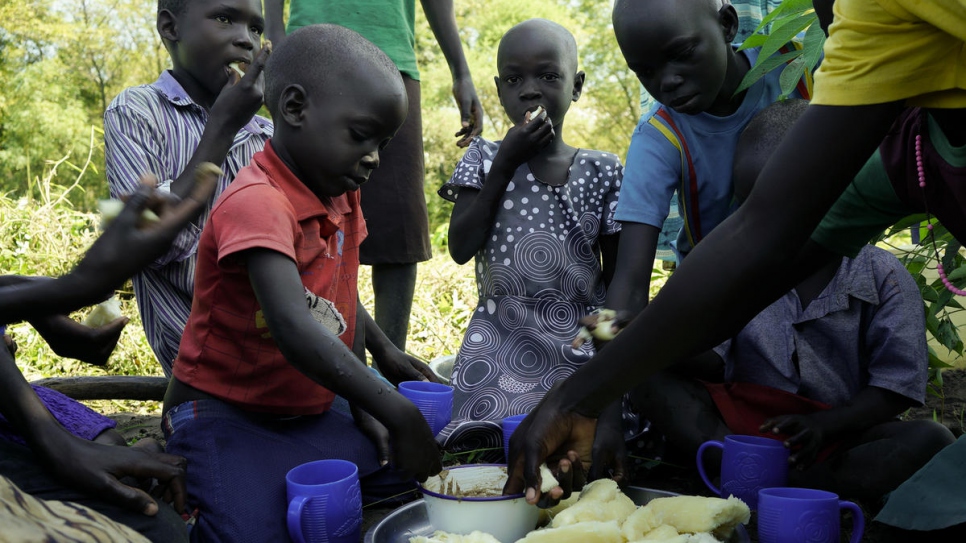 Kinderen nemen een lunchpauze nadat ze hun moeder Queen hebben geholpen. © UNHCR/Michele Sibiloni