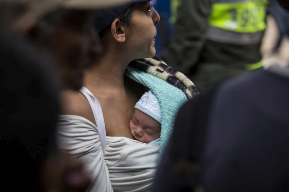 Een vrouw en haar baby uit Venezuela komen eten in de gemeenschappelijke keuken 