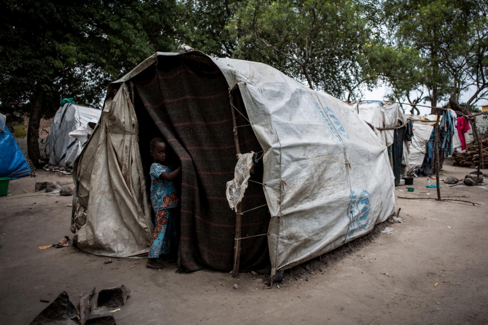 Een kind staat bij een tent op een plek voor ontheemden in Kasenyi. © UNHCR/John Wessels