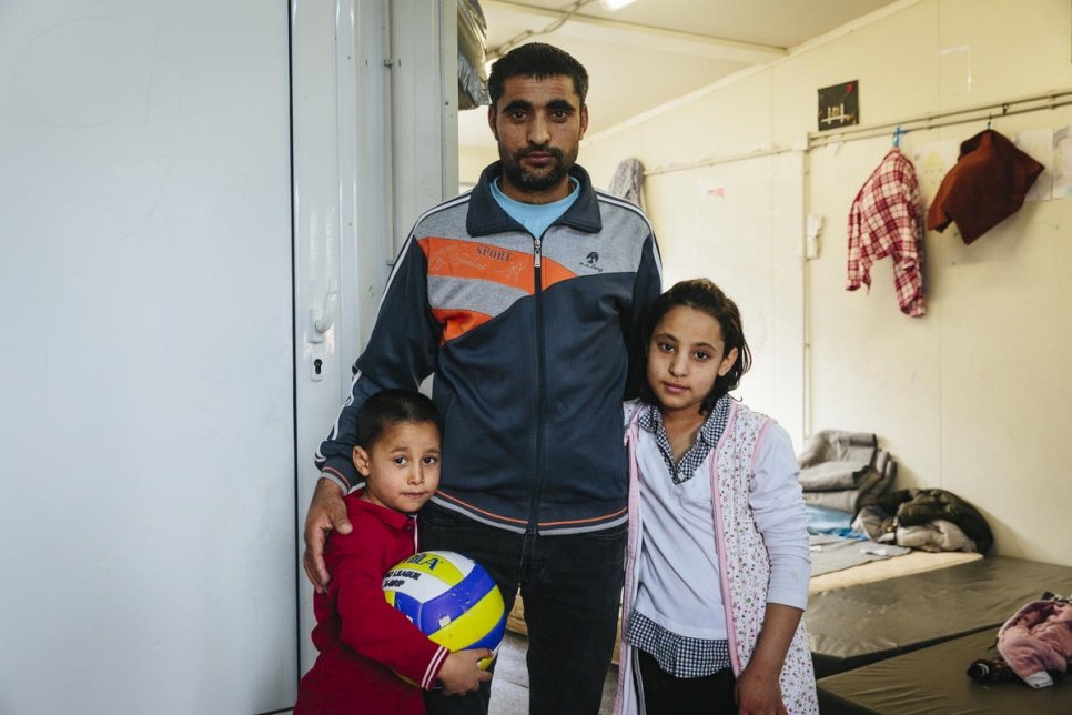 Een Afghaanse asielzoeker staat met twee van zijn kinderen in een opvangcentrum in Fylakio, Griekenland, februari 2020. © UNHCR/Achilleas Zavallis