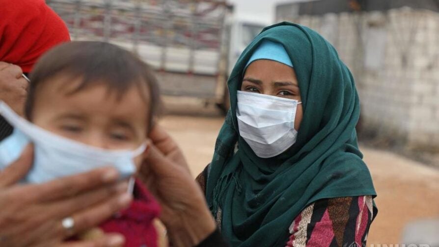 Een Syrisch kind in Idlib krijgt een beschermend gezichtsmasker na een voorlichting over preventiemaatregelen tegen corona. © Ritzau Scanpix