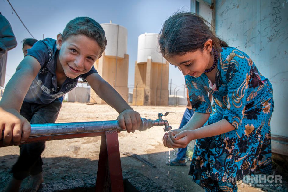 Syrische gevluchte kinderen in Irak bij waterpomp