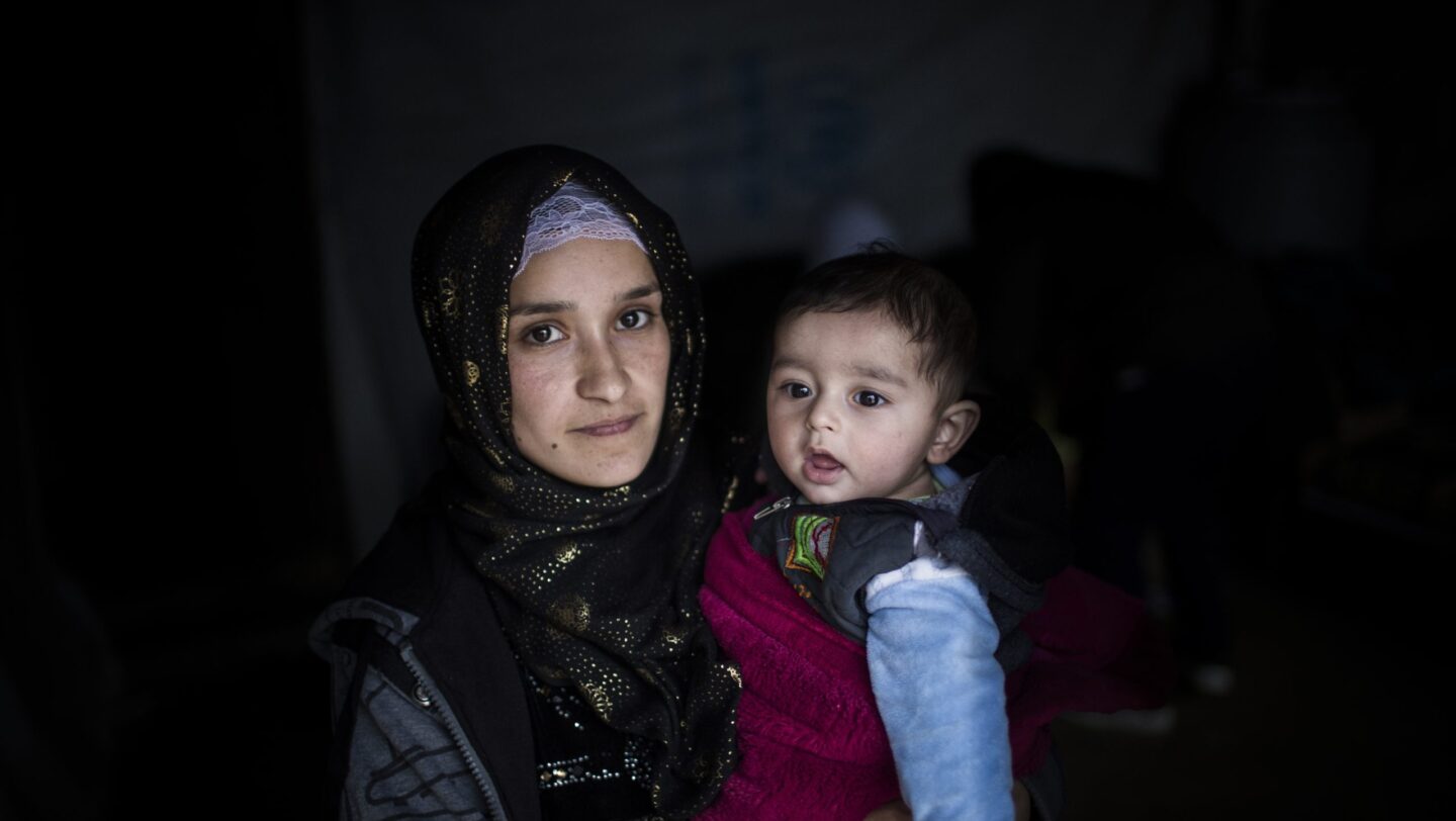Hakima, 21, uit Deir ez-Zor in Oost-Syrië, met haar baby Jad in de vluchtelingennederzetting Bar Elias in centraal Libanon. Hakima is al vijf jaar in Libanon en woont met haar man in het huis van haar zwager, nadat dat van hen overstroomde tijdens storm Norma. © UNHCR/Diego Ibarra