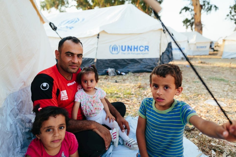 De Syrische vluchteling Mohammed Sadik Jalani en zijn kinderen zitten naast tenten die zijn opgezet door de Griekse autoriteiten en UNHCR om onderdak te bieden nadat branden het opvang- en identificatiecentrum van Moria op het Griekse eiland Lesbos hebben verwoest. © UNHCR