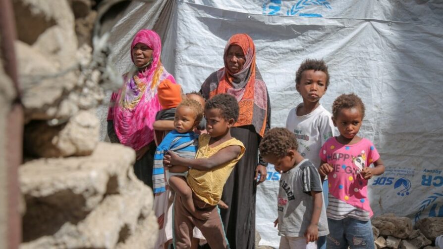 Een ontheemde Jemenitische moeder, Gabra (in het roze) en haar gezin, in een gastgezin in Sana'a. © UNHCR/Ahmed Haleen