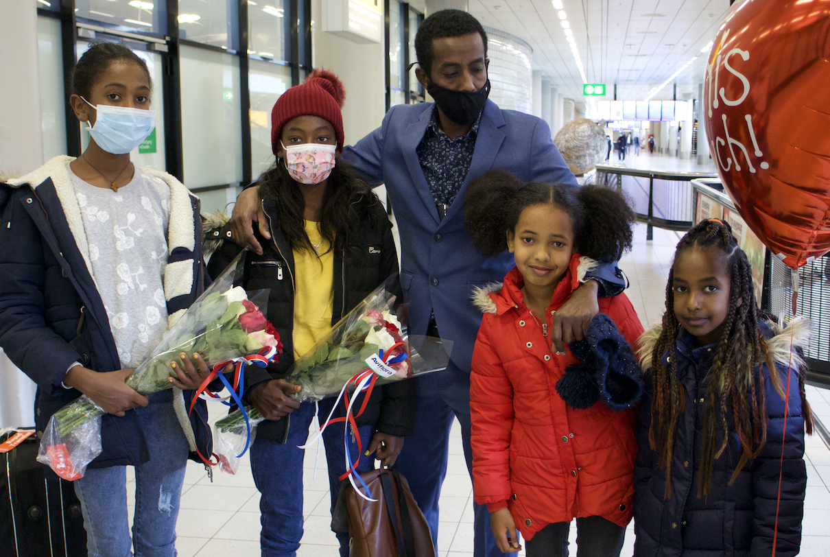 Girmay met zijn vier dochters op vliegveld Schiphol. © UNHCR/Babiche Routledge