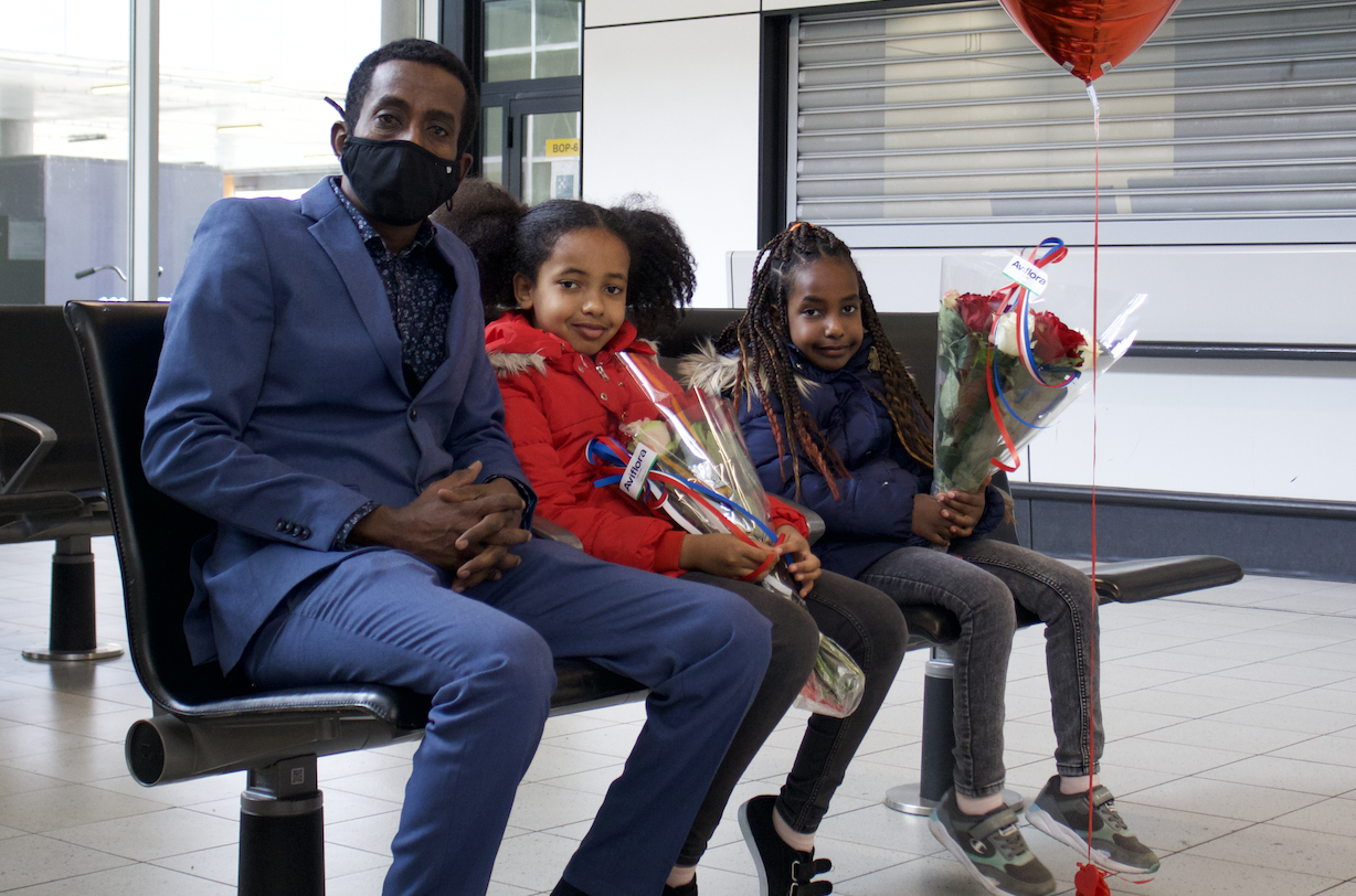 Girmay wacht op Schiphol op de aankomst van zijn dochters Kyara en Sara, samen met zijn twee andere dochters Sinit en Yodit, die halfzusjes zijn van Kyara en Sara. © UNHCR/Babiche Routledge