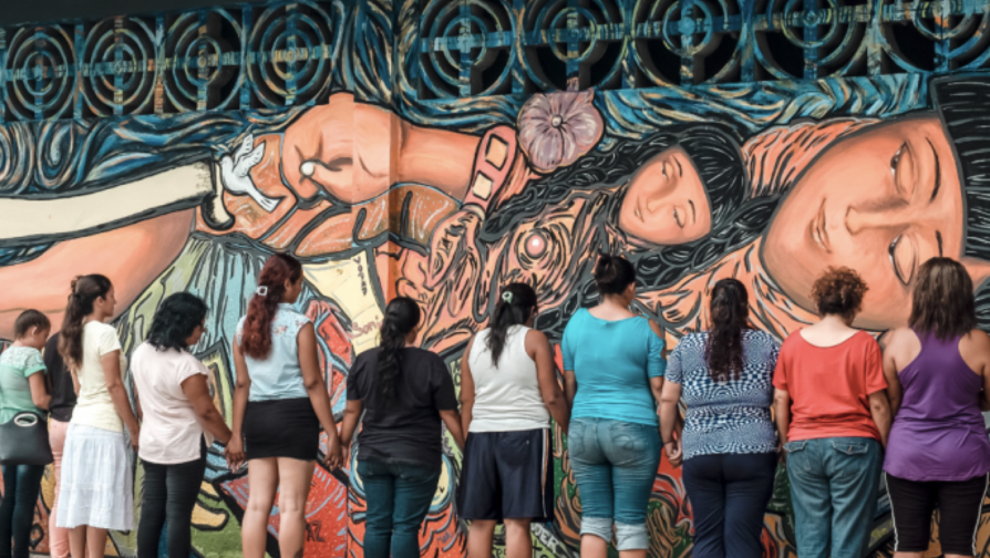Gevluchte vrouwen in Mexico een muur geschilderd