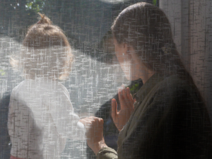 Mother looking at her daughter through a window