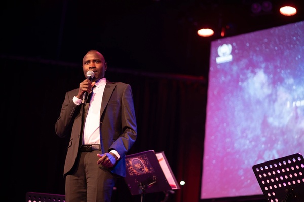 Adam, from Sudan, shares his story about fleeing Sudan and his experiences in Libya, on the Maxim Theatre stage ©Ivanna Stytsun