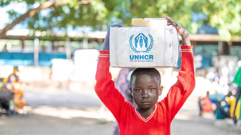 Boy holding a box with UNHCR's logo on