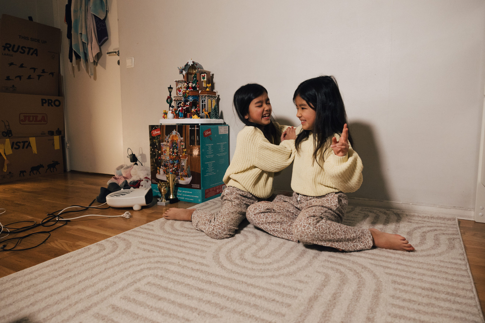 A couple of young girls sitting on the floor
