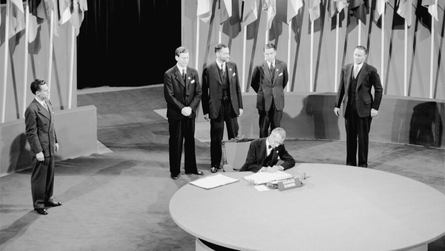 A group of men standing around a table