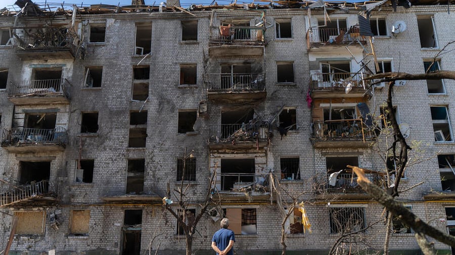 A man standing in front of a destroyed building