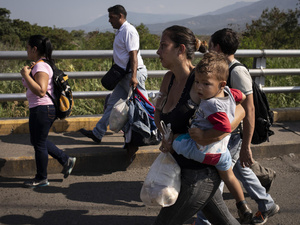 A Venezuelan mother holds her child as she crosses the Simon Bolivar Bridge to Colombia, in  January 2019.