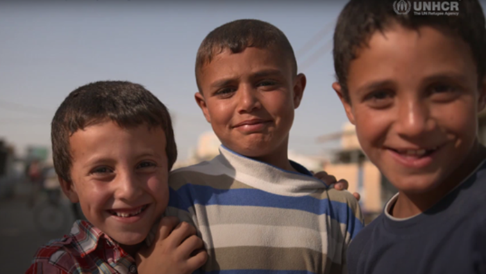Three young boys smile at the camera